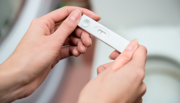отрицательный тест на беременность в руках 